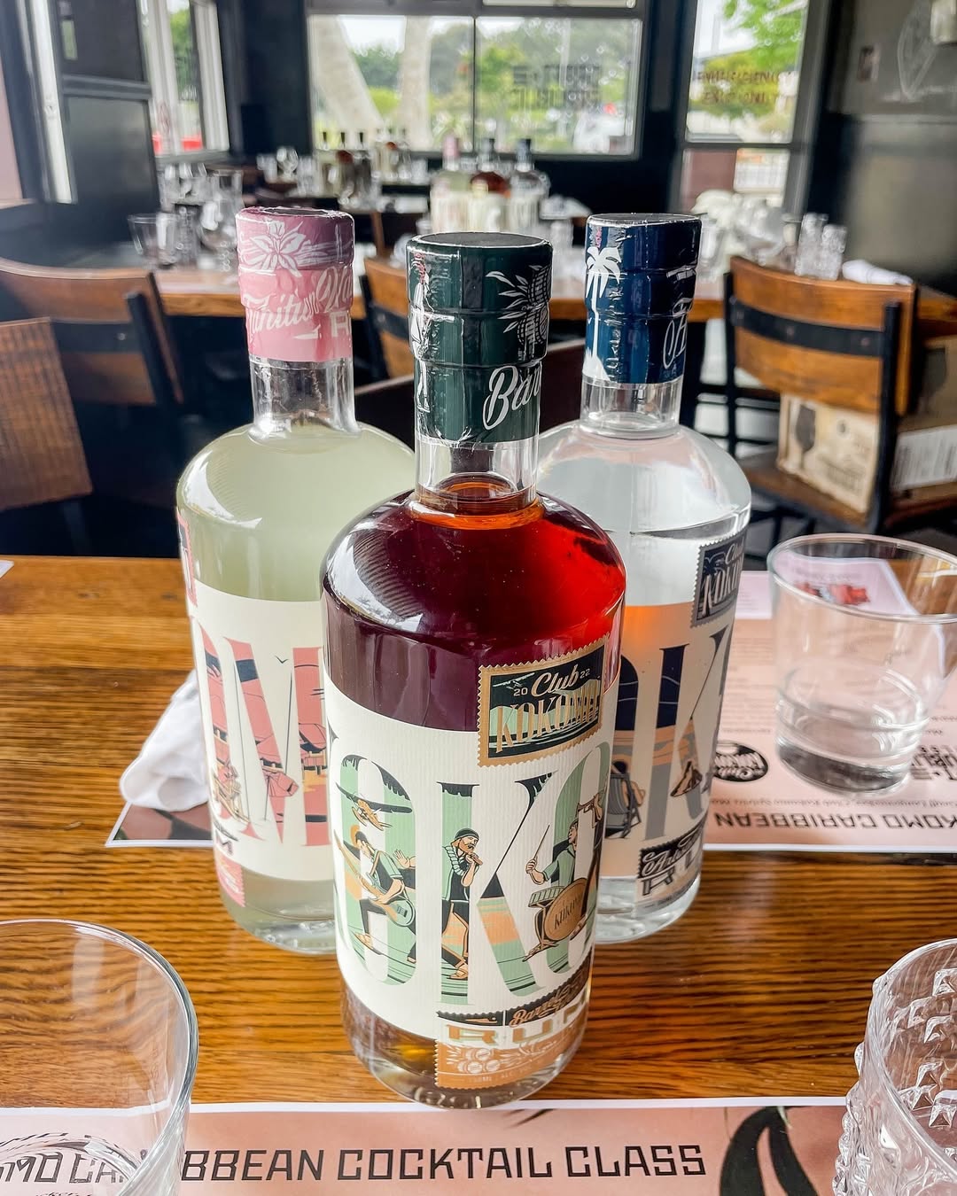 A selection of premium rum bottles displayed on a table during a Caribbean cocktails class, featuring elegant label designs.