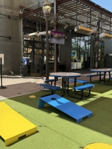 draft republic corn hole area A recreational outdoor space with multiple corn hole boards and picnic seating, ideal for casual games and dining.